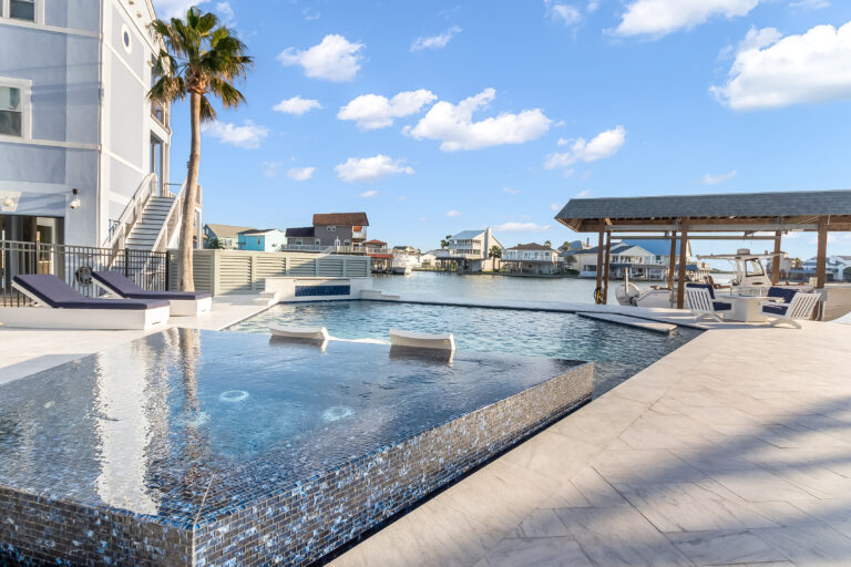 Waterfront backyard pool overlooking a canal and boat docks